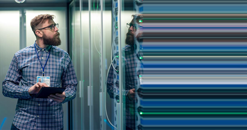 Man looking at servers in data center